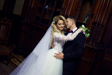 Beautiful young couple, the bride and groom. Dark wooden interior.