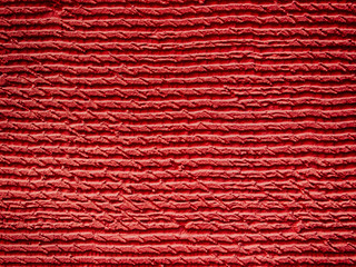 Red peeled textured painted concrete wall surface.