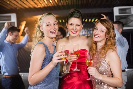 Portrait of female friends holding a glass of champagne