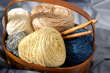 Ball of yarn beige tone in basket on fabric