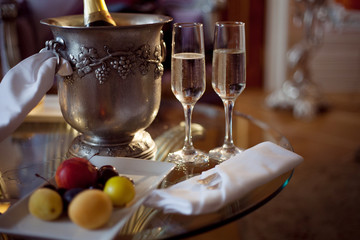 Still life, romantic dinner, two glasses and champagne in the ice bucket. Celebration or holiday