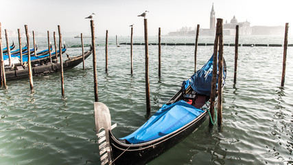 Fototapeta na wymiar The mooring of boats in foggy Venice