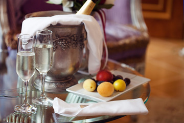 Fototapeta na wymiar Still life, romantic dinner, two glasses and champagne in the ice bucket. Celebration or holiday