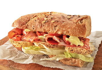 Sandwich with chicken fillet, bacon, lettuce and tomato on wholemeal French bread. Copyspace.