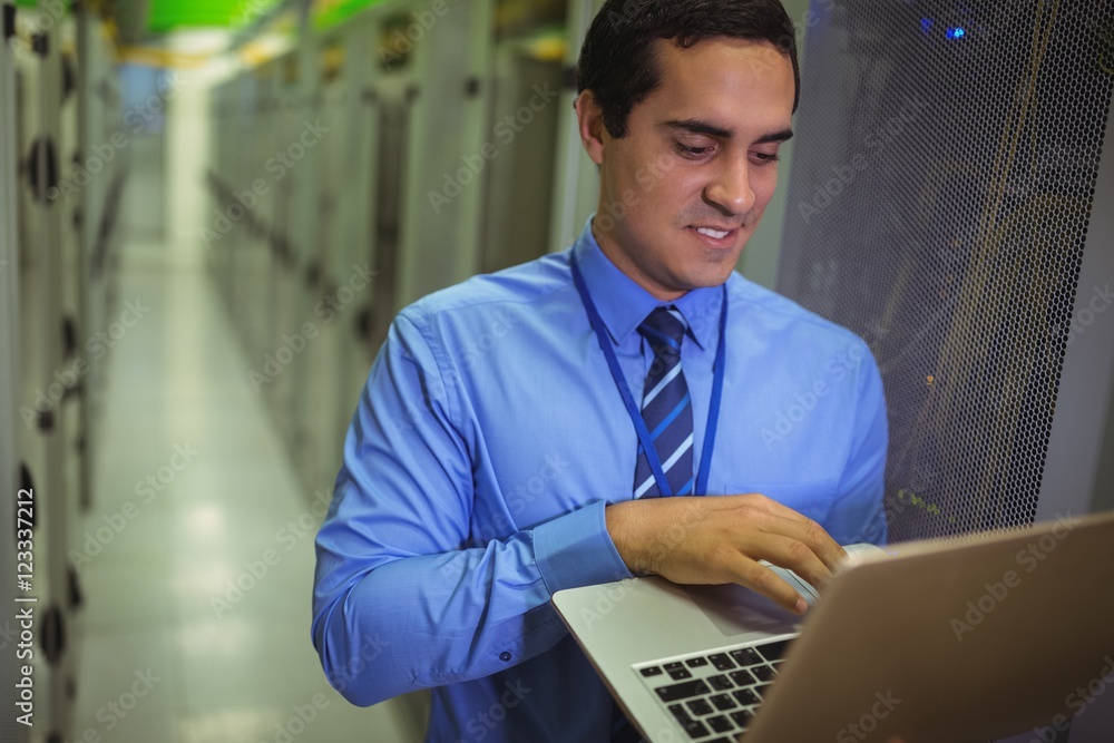 Poster Technician using laptop while analyzing server