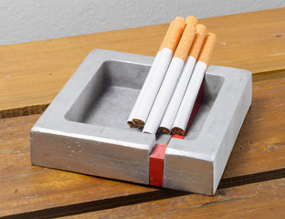 cigarette and ashtray  on wood table