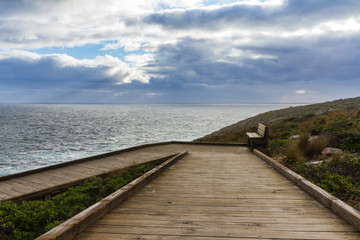 Fototapeta premium Stormy clouds with a wooden walkway in Australia, Kangaroo Island