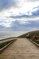 Fototapeta premium Stormy clouds with a wooden walkway in Australia, Kangaroo Island
