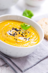 Homemade vegetable soup with pumpkin with cream and black sesame, closeup