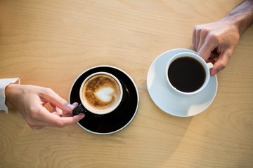 Hands of couple holding cup of coffee