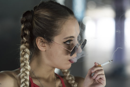 Stylish girl in sunglasses with cigarette