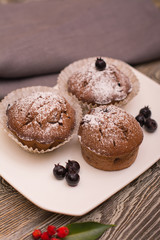 cupcake with berries on a white plate, wooden background