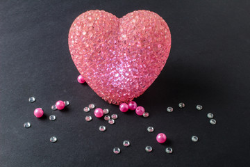 shining heart with rhinestones and beads on a black background