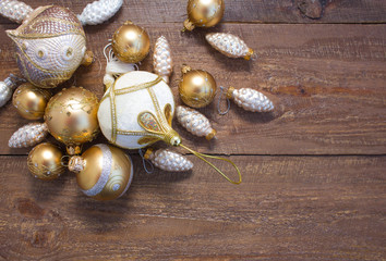 Fototapeta na wymiar Christmas or New Year background: fur-tree branches, colorful glass balls, decoration and glittering stars on wood background