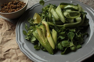 vegan salad with cucumber, lentil, avocado on a gray plate. healthy eating every day.