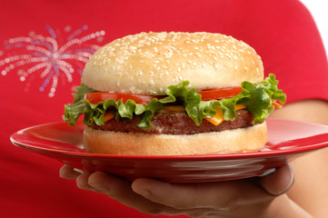 Woman holding hamburger on white background