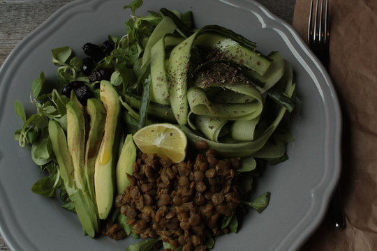 vegan salad with cucumber, lentil, avocado on a gray plate. healthy eating every day.