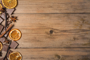 chocolate with cinnamon, orange and vanilla on wooden table