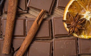 chocolate with cinnamon, orange and vanilla on wooden table
