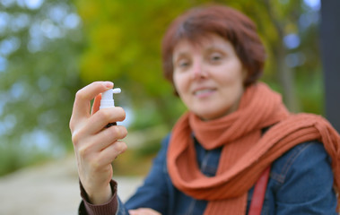 Young woman using throat spray