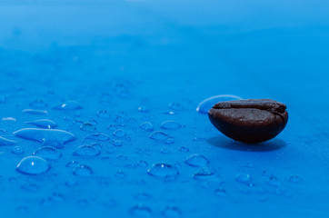Water droplets on blue fiber waterproof fabric with coffee beans