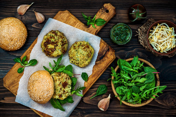 Zucchini quinoa veggie burger with pesto sauce and sprouts. Vegetarian burger on a cooking sheet...