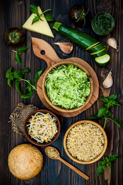 Raw ingredients for vegetarian dinner recipe. Preparing veggies cutlets or patties for burgers. Zucchini quinoa veggie burger with pesto sauce and sprouts. Top view, overhead, flat lay