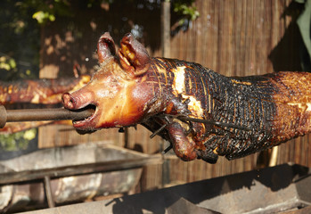 A whole pig slow cooked on an outdoor grill