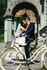 Obraz na płótnie Canvas Bride kisses groom on bicycle