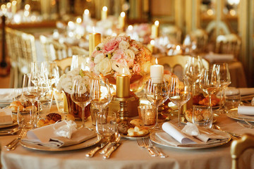 Plates with bread stand among sparkling glassware on table serve