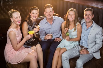 Friends holding glasses of cocktail in bar