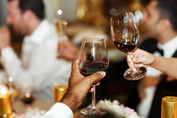 Man and woman clang glasses with red wine