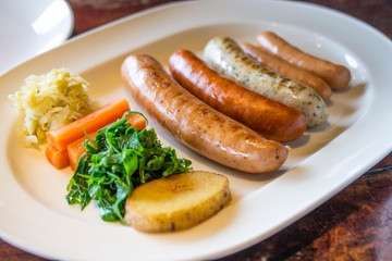 Sausage grill with vegetable on white dish