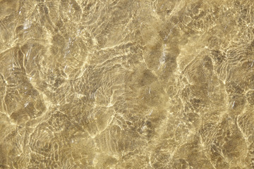 A full page of shallow sea water ripples over a yellow sand background texture