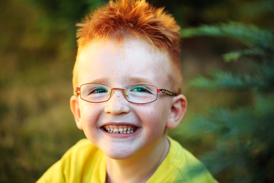 Happy Baby Boy With Red Hair In Glasses