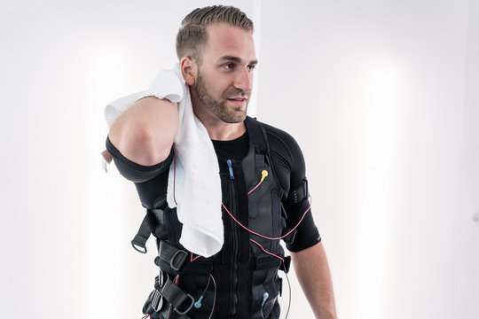 Exhausted man wiping sweat with towel after EMS training