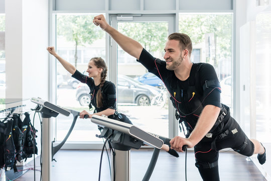Two sportive people having training session in EMS studio gym