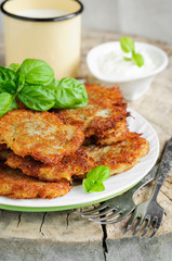 Fried potato pancakes decorated with basil leaves