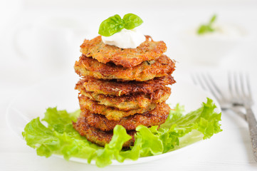 Potato pancakes with sour cream and lettuce
