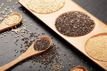 Quinoa, chia and amarantus seeds in wooden spoons