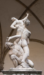 Fototapeta na wymiar The Rape of the Sabine Women by Giambologna, in the Loggia dei Lanzi in Florence, Italy. Famous sculpture displayed in the Old Town.