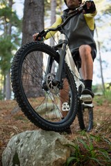 Fototapeta na wymiar Male mountain biker riding bicycle in the forest
