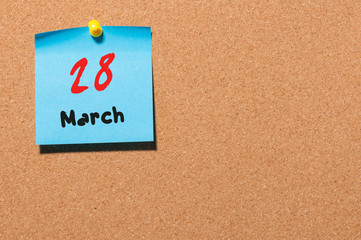 March 28th. Day 28 of month, calendar on cork notice board background. Spring time, empty space for text