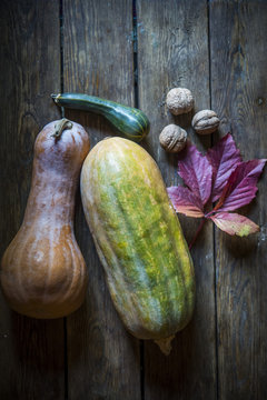 pumpkin nuts and zucchini on a wooden surface with an autumn petal