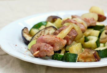 Skewer with roasted turkey hen meat with onion, zucchini and aubergine on white plate