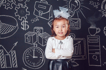 Little smart girl standing and folded hands on dark background with business or school picture