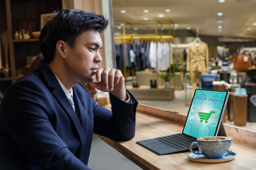 Businessman sitting and using computer laptop showing the shoppi