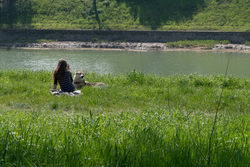 Ragazza sola in riva al fiume con il cane