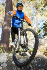 Fototapeta premium Male mountain biker riding bicycle in the forest