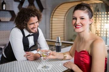 Portrait of beautiful woman standing at bar counter
